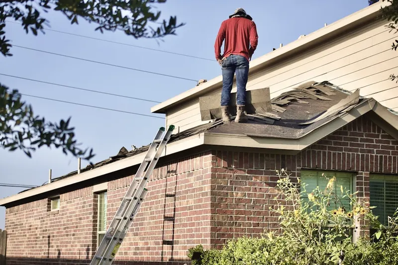 Professional roofer working on a residential roof in Aliso
